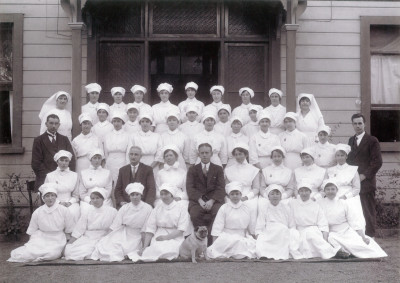 A black and white group photo of nursing staff all wearing white, from the early 1990s 