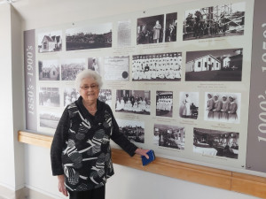 Volunteer WDHB Archivist Ailsa Stewart with the displayed historical taonga in the hospital corridor